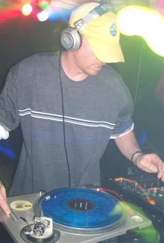 DJ Natural Nate® on the turntables under stage lights